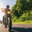 man riding a motorcycle on an empty and rural road