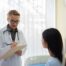 woman doctor speaking with her patient in her office