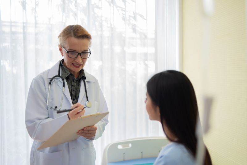 woman doctor speaking with her patient in her office