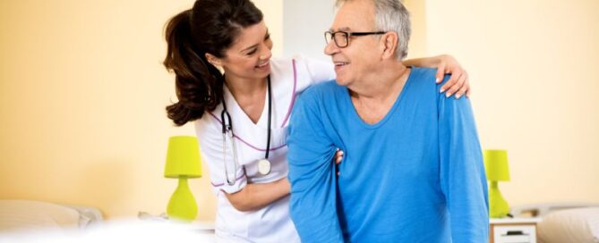 Young female nurse accompanying an older male patient
