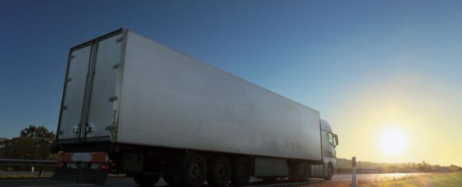 Semi truck on the highway driving into sunset