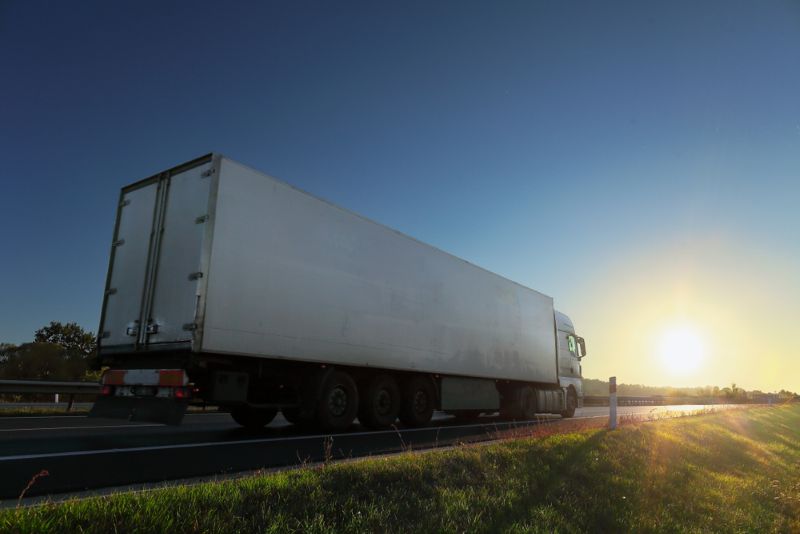 Semi truck on the highway driving into sunset